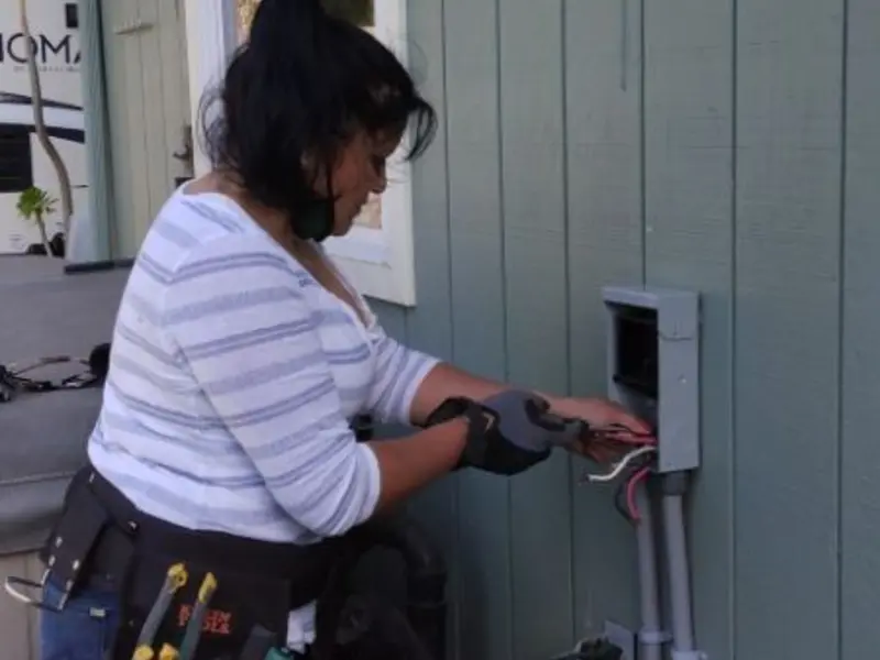 Licensed electrician wiring an exterior subpanel in Orange